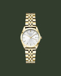 A gold-tone wristwatch with a white dial and a matching gold-tone link bracelet, shown against a solid off-white background. The brand name 'Bosefield' is visible on the dial.