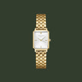Gold watch with a white face on a light gray background