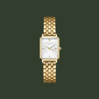 Gold watch with a white face on a light gray background