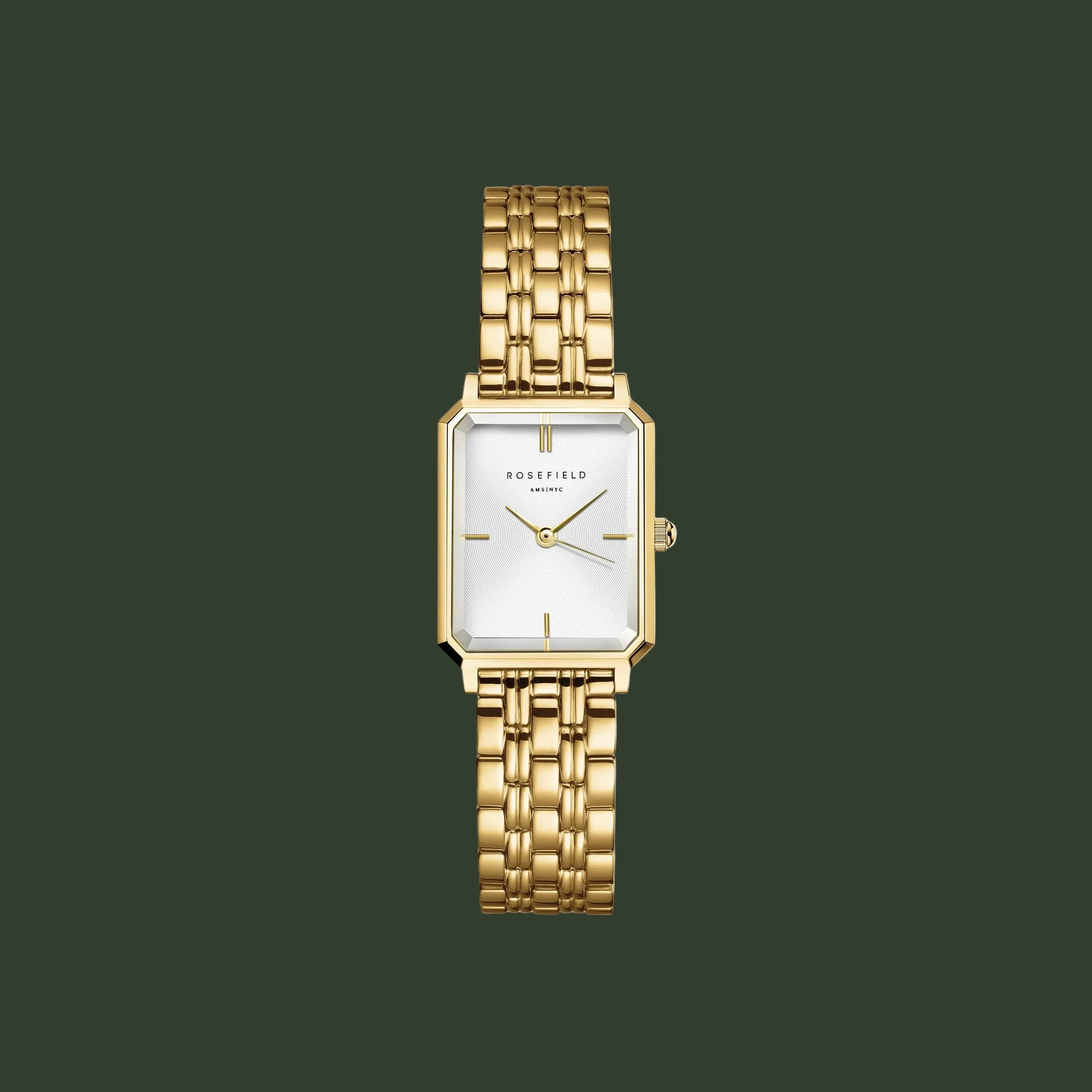 Gold watch with a white face on a light gray background