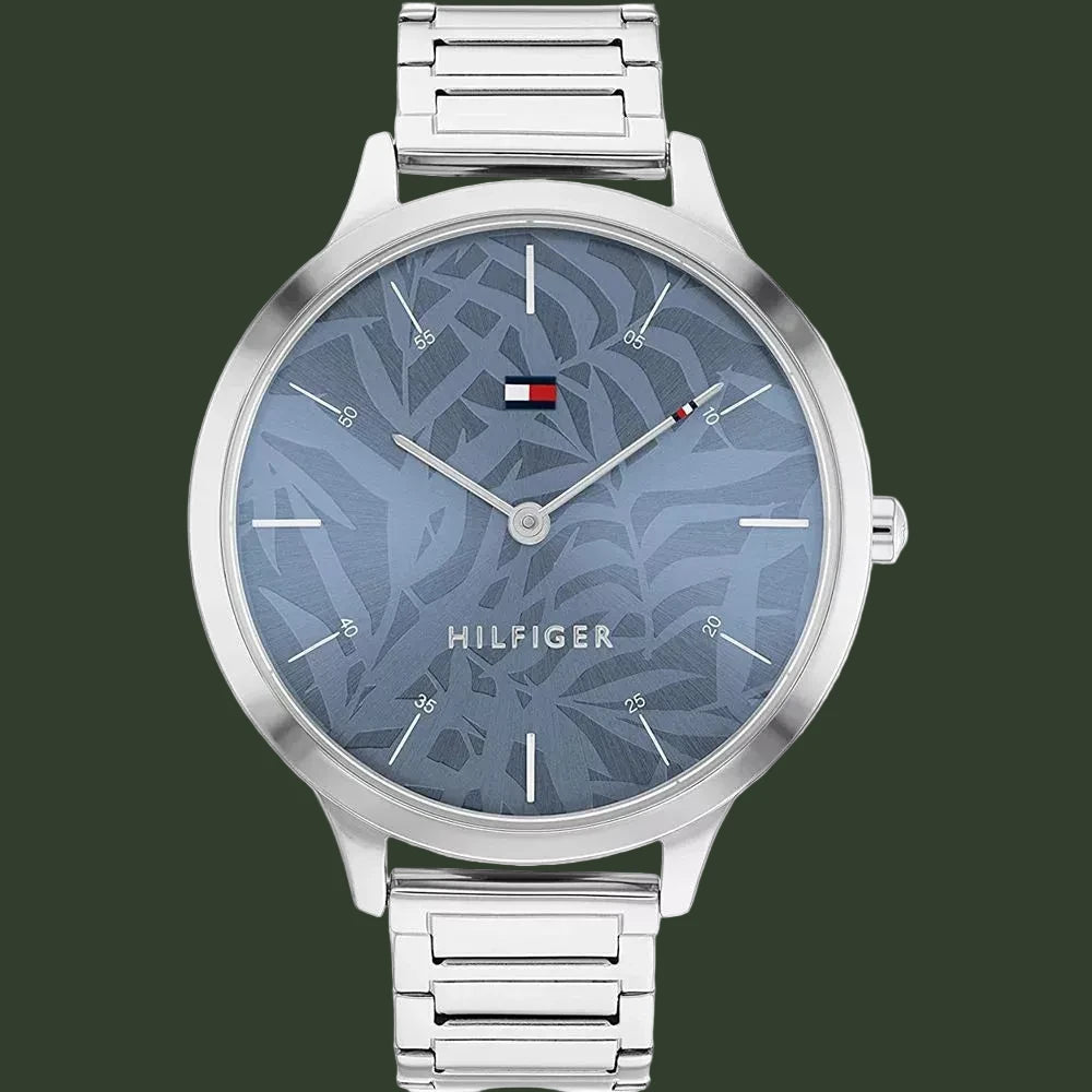 A silver-tone Tommy Hilfiger analog watch with a blue patterned dial and a matching silver-tone metal link bracelet, shown against a plain white background.