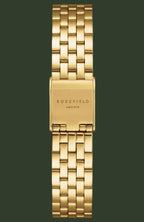 A gold-tone stainless steel link watch band with a rectangular clasp engraved with 'ROSEFIELD ANHANT' in black, shown against a plain white background.