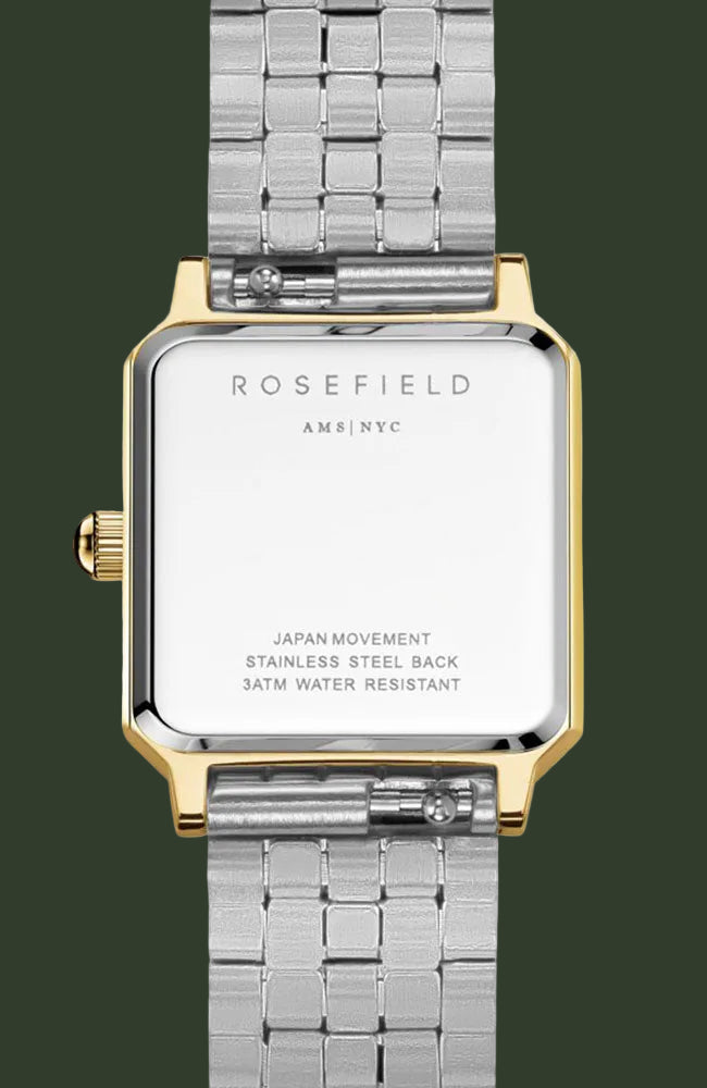 Rosefield women's watch with a silver stainless steel link bracelet and a gold-tone case, showing the back of the watch with engraved text on a white background.