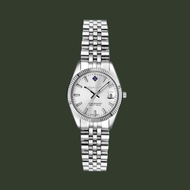A silver-tone stainless steel watch with a fluted bezel, silver link bracelet, and a white dial featuring a date window and black hands.