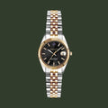 Gold wristwatch with a brown dial on a white background
