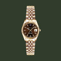 Gold wristwatch with a brown dial on a white background
