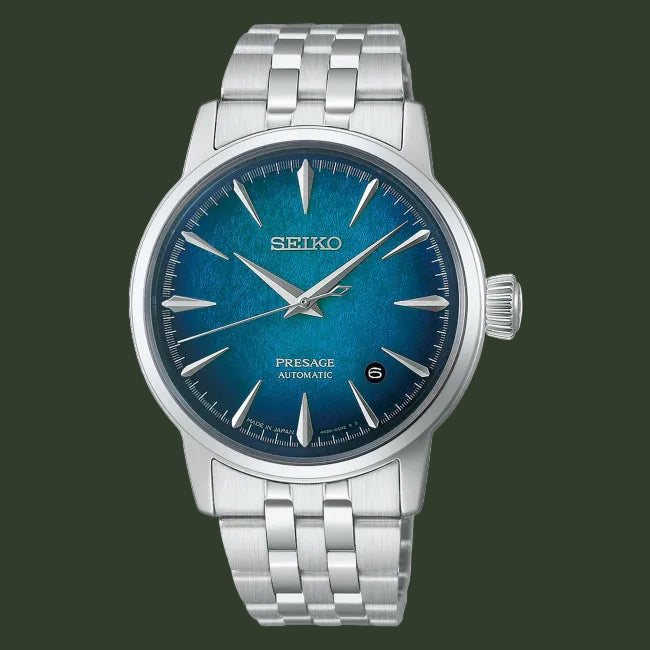 A Seiko Presage Automatic watch with a silver stainless steel case and link bracelet, featuring a textured blue dial with silver-tone hands and hour markers.