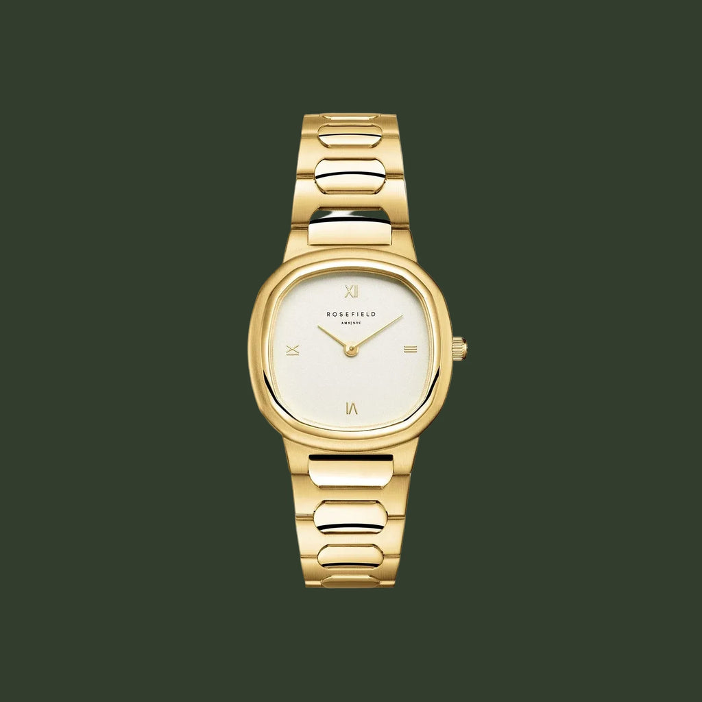 Gold watch with a white face on a light beige background