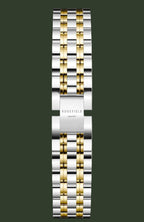 A two-tone stainless steel and gold watch band with a polished finish, featuring the ROSEFIELD brand name engraved on the central clasp, set against a light beige background.