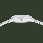 Close-up side view of a silver stainless steel watch with a matching metal link bracelet, featuring a textured crown guard and polished bezel on a white background.