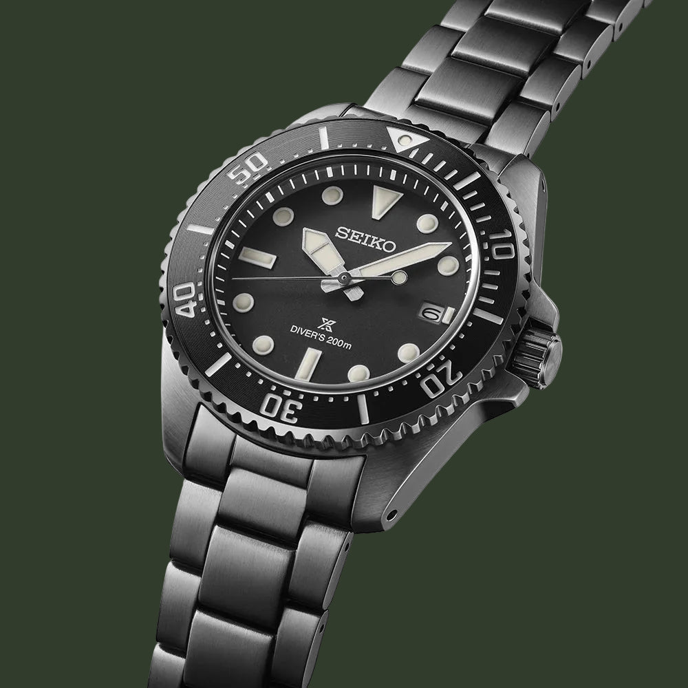 Seiko watch with black dial and silver metal bracelet on a white background