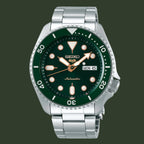 A Seiko automatic dive watch with a dark green dial and bezel, a silver stainless steel case and bracelet, and luminous orange hour markers.