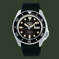 A Seiko automatic watch with a black dial, black bezel, and a textured black rubber strap, shown against a plain white background.