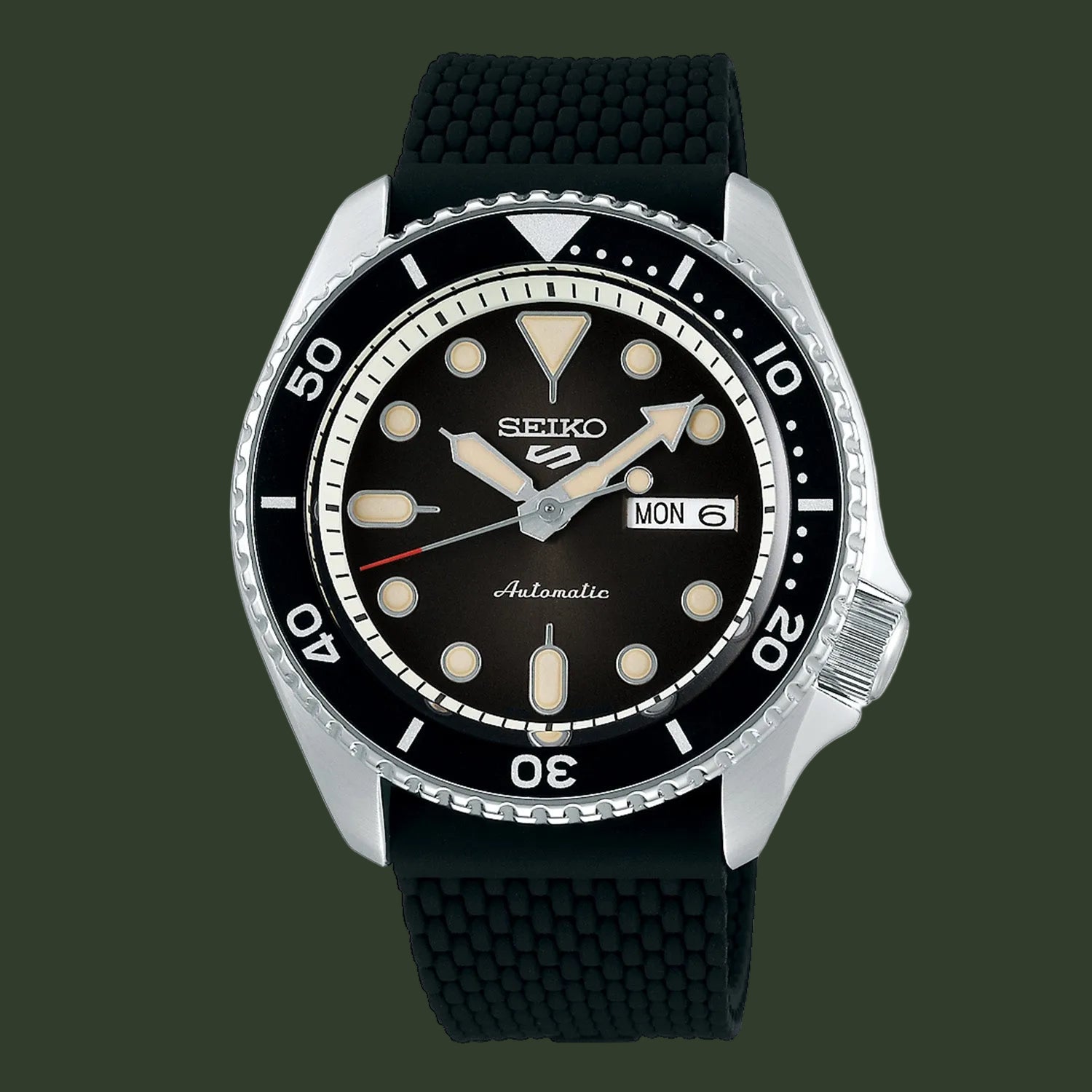 A Seiko automatic watch with a black dial, black bezel, and a textured black rubber strap, shown against a plain white background.