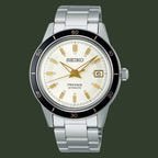 A Seiko Presage Automatic watch with a silver stainless steel link bracelet, a cream-colored dial with gold-tone hands and markers, and a black rotating bezel.