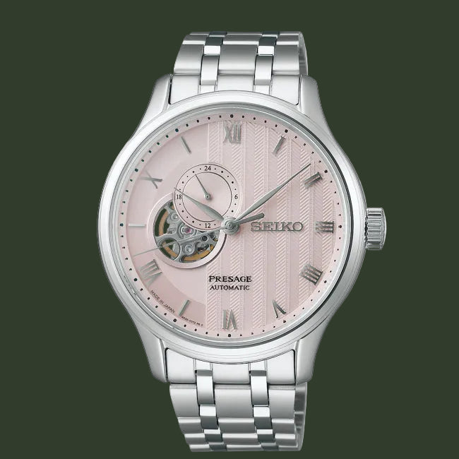 Seiko watch with pink face and silver metal strap on white background