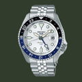 Seiko watch with silver metal bracelet and blue bezel on a white background