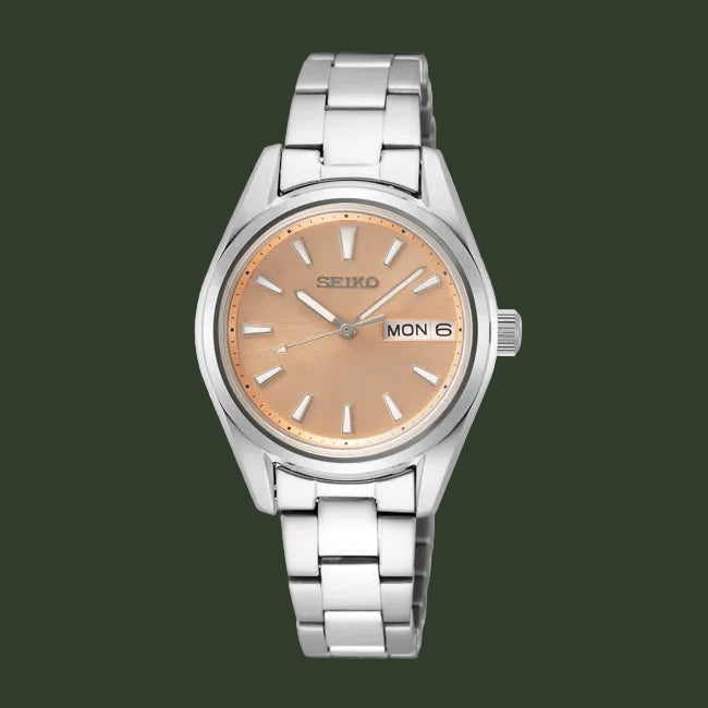 A Seiko women's analog watch with a silver stainless steel link bracelet, a round silver case, and a warm champagne-gold dial with silver hour markers and hands.