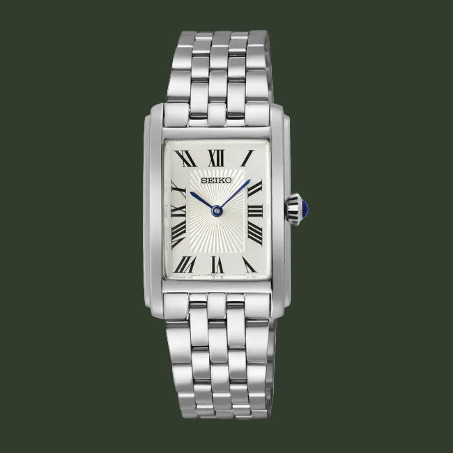 A Seiko women's analog watch with a silver-toned stainless steel link bracelet, a rectangular silver case, a white sunburst dial with black Roman numerals, and blue hands.