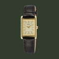 A Seiko women's watch featuring a gold-tone rectangular case, a cream-colored dial with gold hands and indices, and a dark brown leather strap with visible stitching.