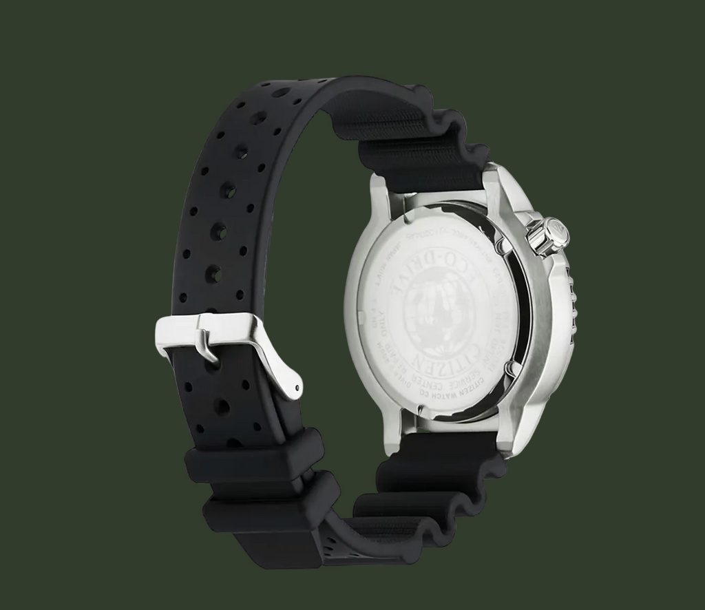 A silver-tone stainless steel watch with a black perforated silicone strap, shown from the back on a clean white background.