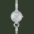A silver-tone Guess bangle watch with a crystal-encrusted bezel, crystal-detailed dial, and signature 'G' bracelet connector, shown on a plain white background.