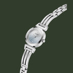 A silver-tone stainless steel women's watch by Guess, featuring a round silver dial with a light blue iridescent gradient center, crystal gemstone hour markers, and a matching multi-link bracelet, shown on a plain white background.