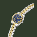 A two-tone stainless steel and gold wristwatch with a blue dial, Roman numeral hour markers, and a fluted gold bezel, shown on a plain white background.