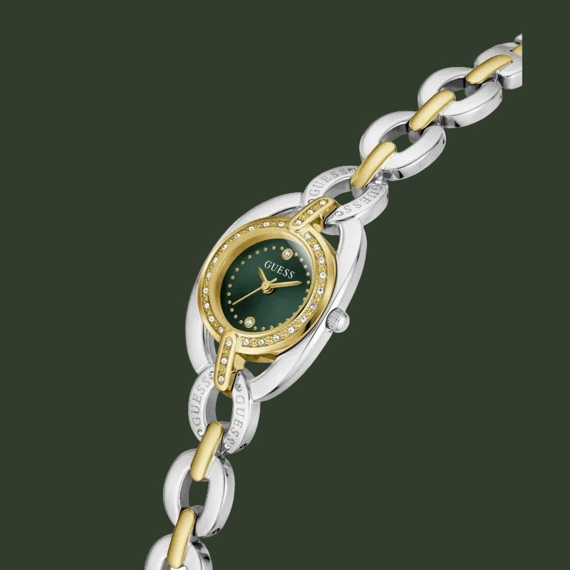A two-tone stainless steel and yellow gold Guess watch with a dark green dial and crystal-encrusted bezel, shown on a white background.
