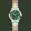 A Guess women's two-tone stainless steel and gold watch with a green dial, Roman numeral hour markers, and a matching green and gold link bracelet, shown on a plain white background.