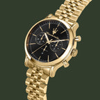 Gold watch with black face on a white background