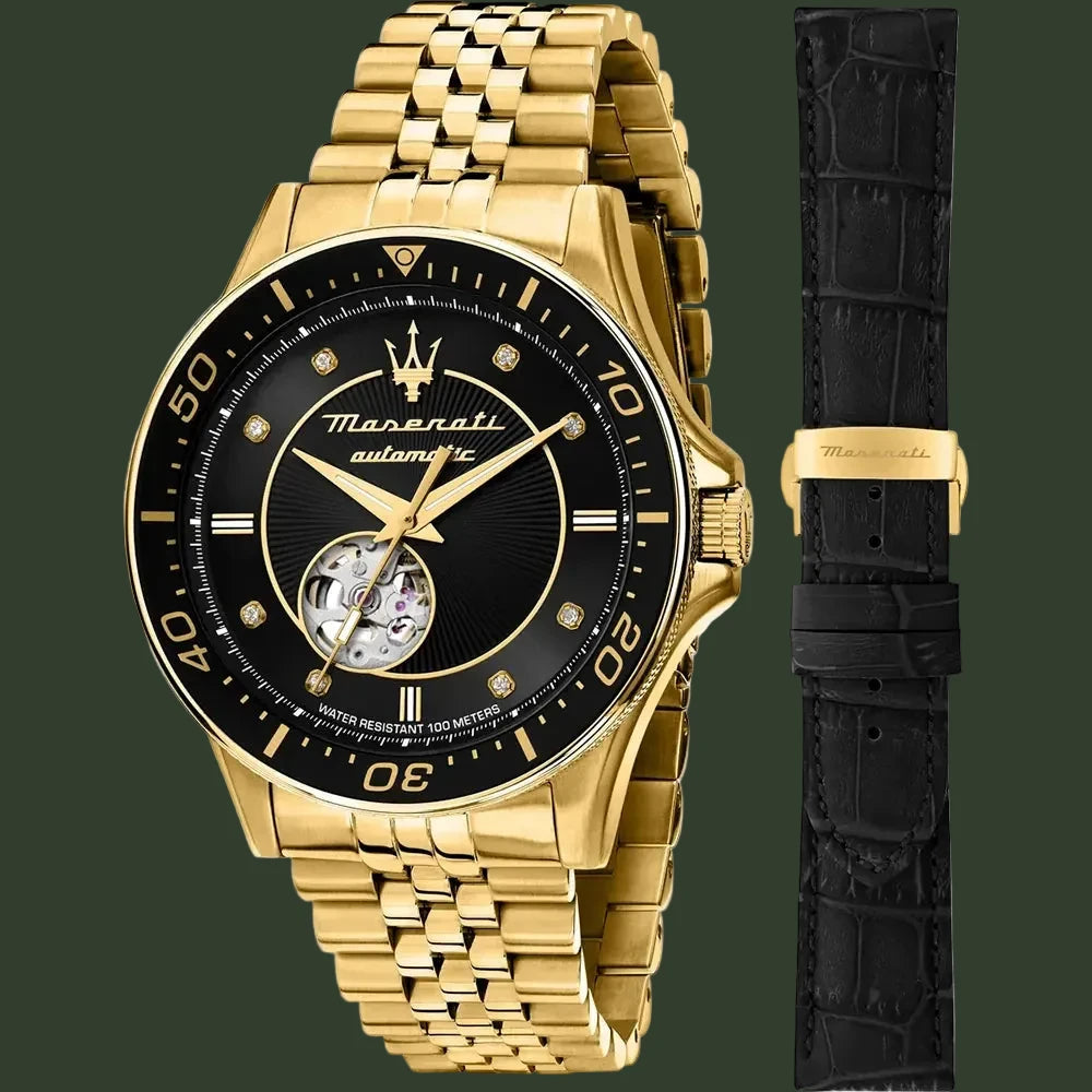 Gold watch with black face and additional black strap on a white background