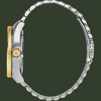 Close-up of a watch with a silver and gold band on a white background