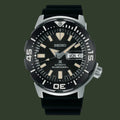 A Seiko automatic diver's watch with a black dial, black strap, and silver-tone case on a plain white background.