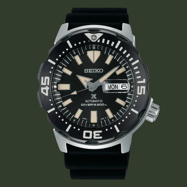 A Seiko automatic diver's watch with a black dial, black strap, and silver-tone case on a plain white background.