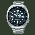 A Seiko Padi Automatic Diver's 200m watch with a silver stainless steel case and bracelet, featuring a black dial with white and blue accents, a black rotating bezel, and a day and date window.
