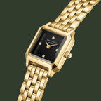Gold watch with a black face on a white background