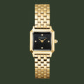 A gold-tone metal watch with a rectangular black dial and a matching gold-tone link bracelet, shown against a plain white background.