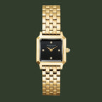 A gold-tone metal watch with a rectangular black dial and a matching gold-tone link bracelet, shown against a plain white background.