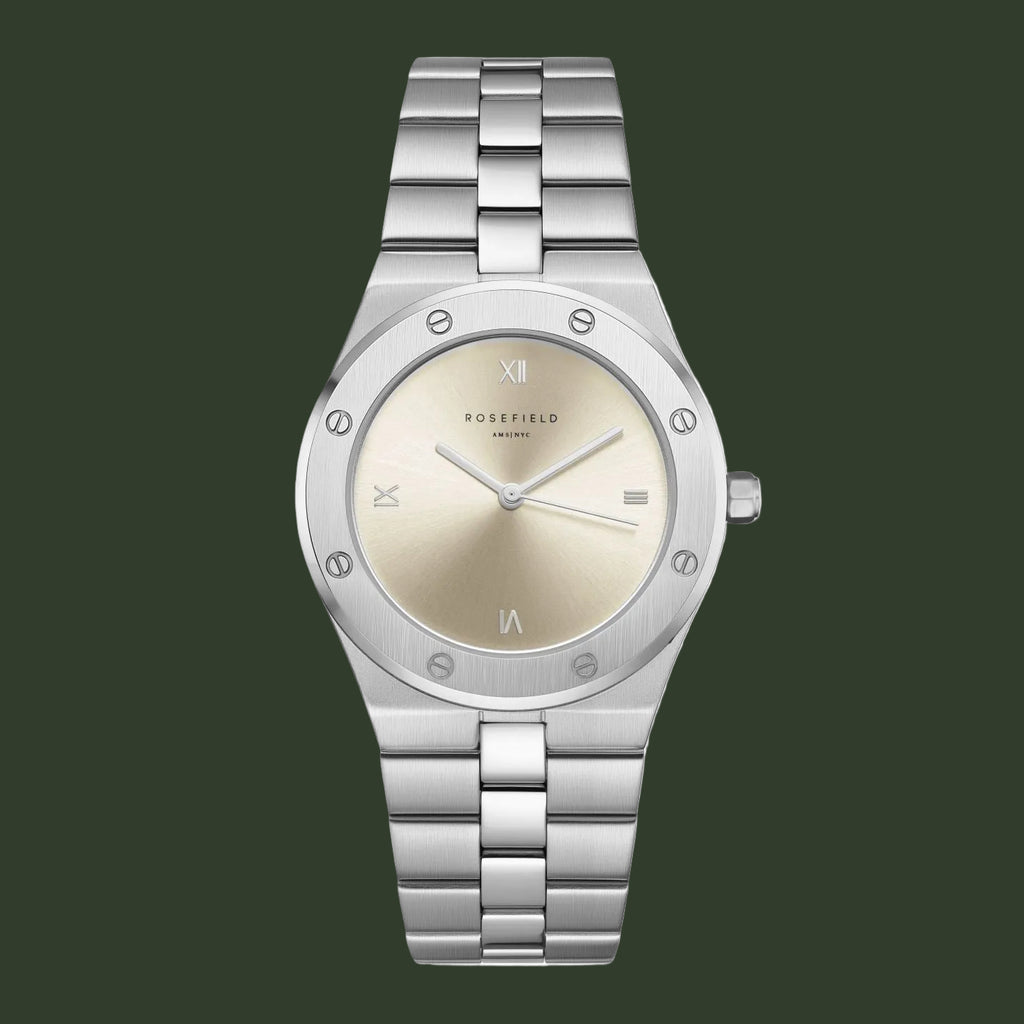 A women's Rosefield watch featuring a silver stainless steel link bracelet, a silver bezel with small crystal accents, and a champagne-gold dial with Roman numeral hour markers.