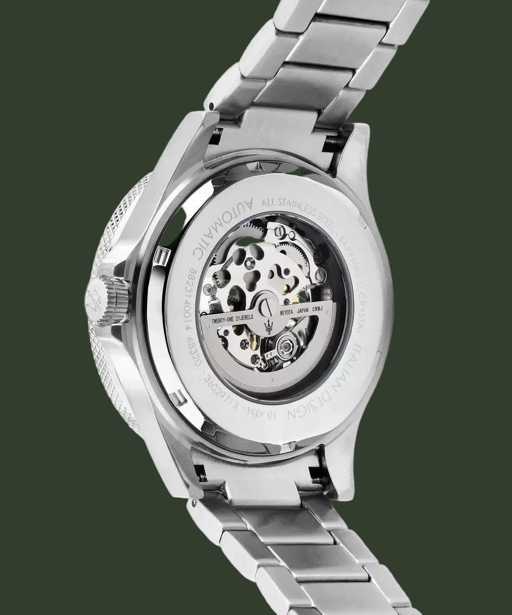 Close-up of the back of a stainless steel wristwatch with a transparent case back showing the mechanical movement, attached to a matching metal link bracelet on a white background.